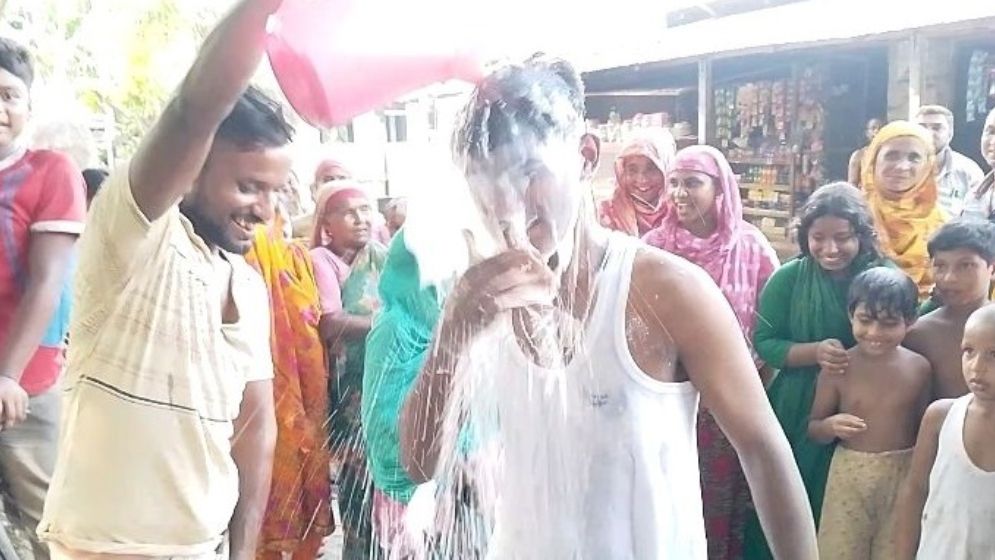 দুধ দিয়ে গোসল করছেন হৃদয় মিয়া। ছবি: যুগান্তর
