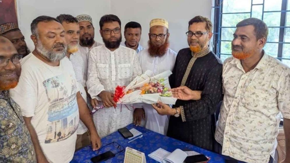 বিএনপি নেতা আবু বকর সিদ্দিককে ফুল দিয়ে বরণ করে নিচ্ছেন জামায়াতের নেতাকর্মীরা। ছবি: যুগান্তর